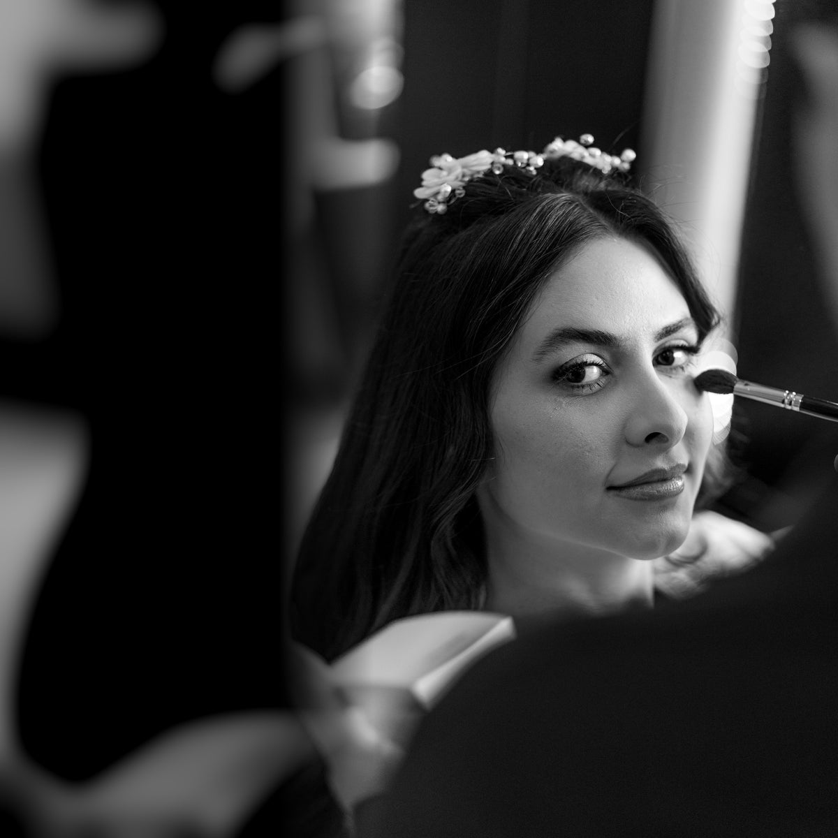 Retrato editorial em preto e branco de Caroline Duó durante a maquiagem