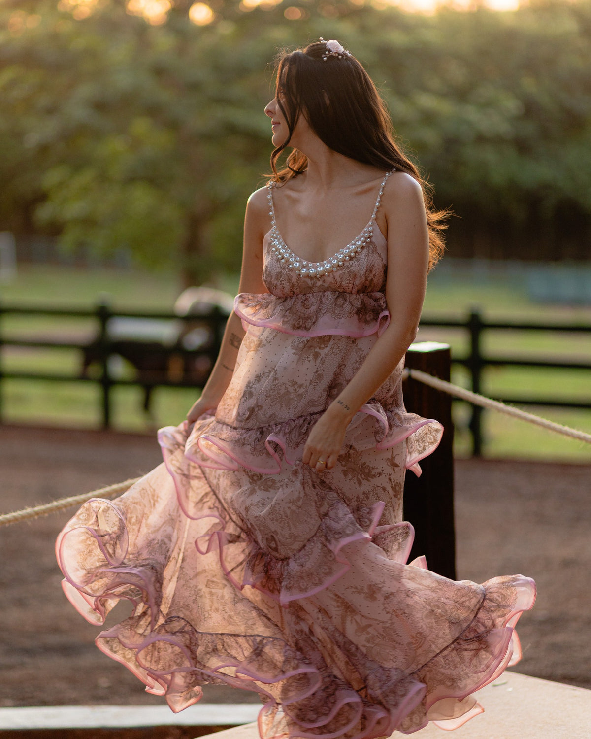 Caroline Duó movimentando o vestido rosa ao pôr do sol.