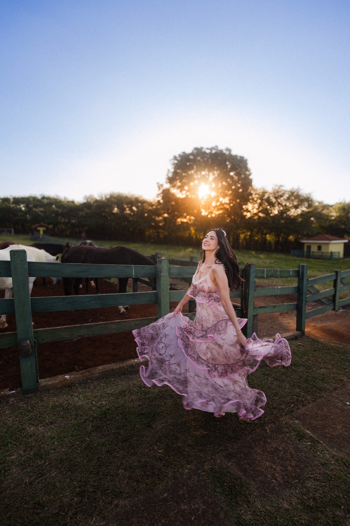 Caroline ao pôr do sol, com o vestido inteiro junto à cerca — Caroline Duó