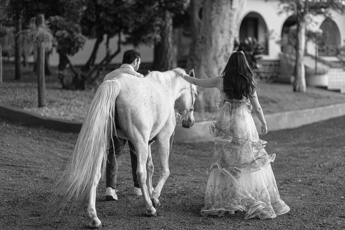 Caroline caminhando com o cavalo, em preto e branco — Caroline Duó